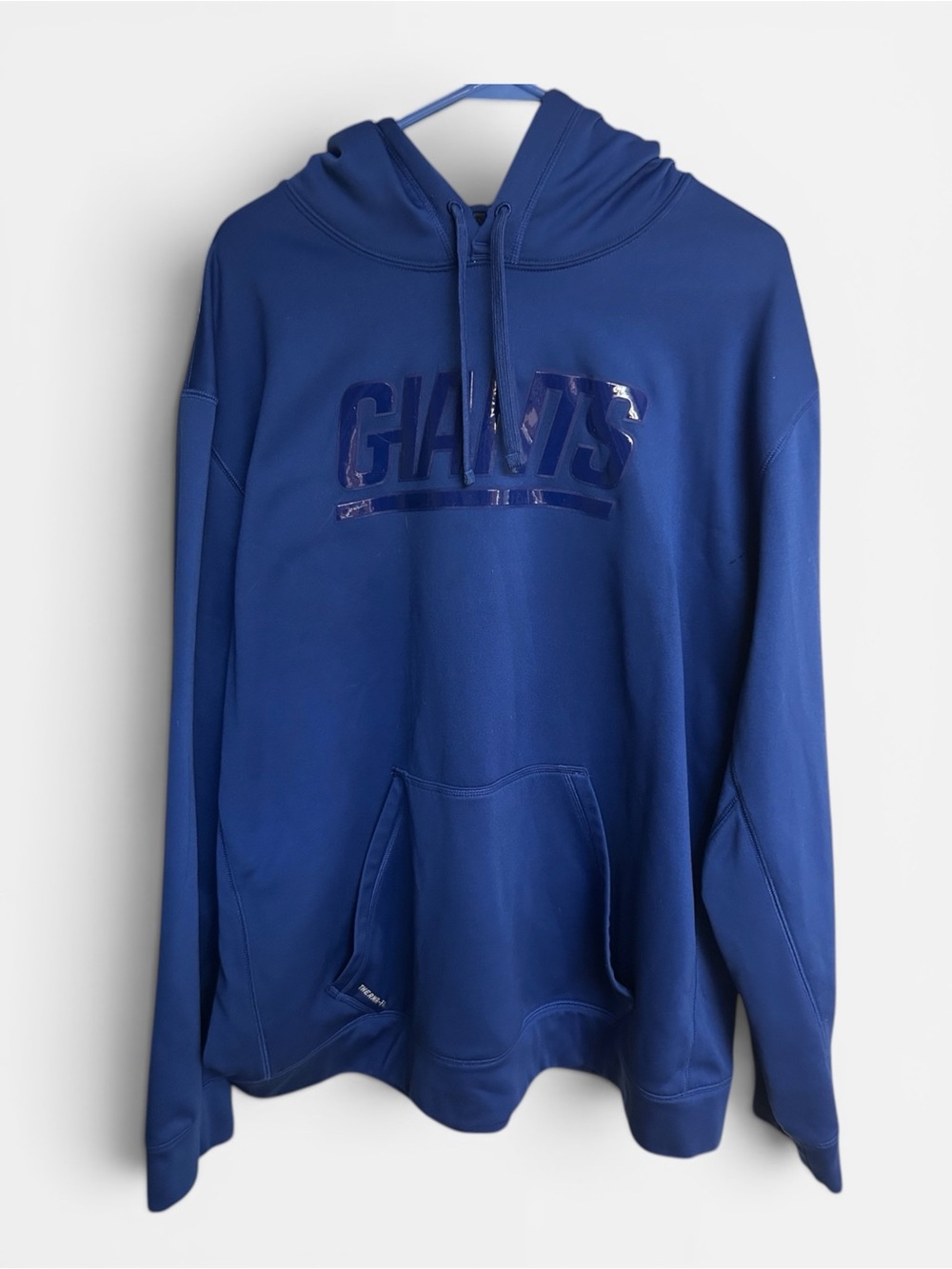 Nike Therma-Fit New York Giants hoodie features a large, glossy wordmark graphic